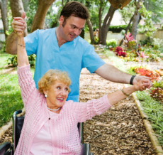a caregiver man assisting the elderly woman on her physical therapy